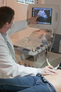 Doctor giving woman a sonogram examination
