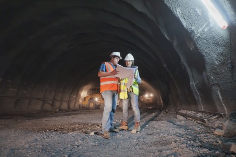 Construction workers looking at blueprint in tunnel