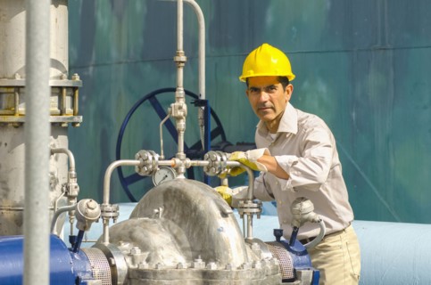 Hispanic worker checking valves