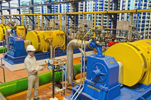 Hispanic worker checking machinery