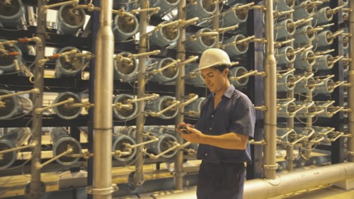 Hispanic worker with cell phone in warehouse