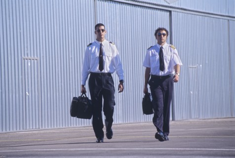 Two pilots walking in front of hangars