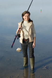 Woman with fishing rod standing in lake portrait elevated view