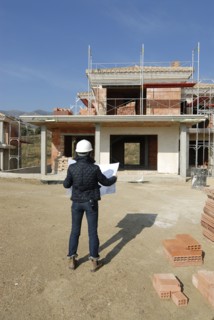 Female architect on construction site looking at plan rear view
