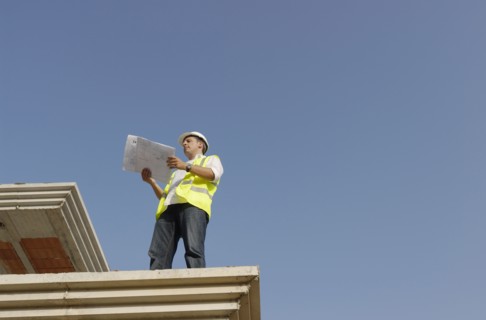 Engineer looking at plan on construction site low angle view