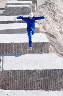 worker jumping between blocks of marble