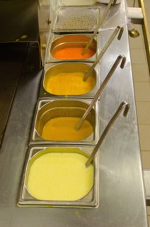 Colored sauces with ladles in restaurant kitchen