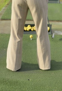 Woman practicing golf rear view low section