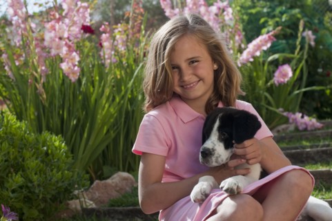 young girl with dog in garden