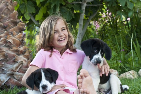 young girl with dogs in garden