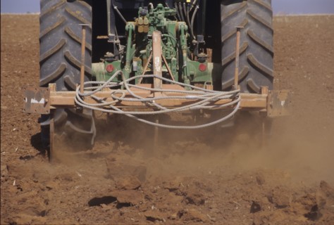 Low Section of a Tractor Ploughing the Soil in a Field