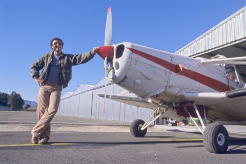 Smiling Man Standing Next to a Monoplane