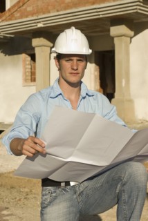 Young architect with plan on construction site