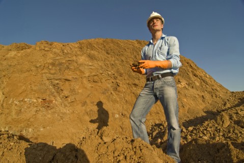 Young engineer checking soil samples on construction site