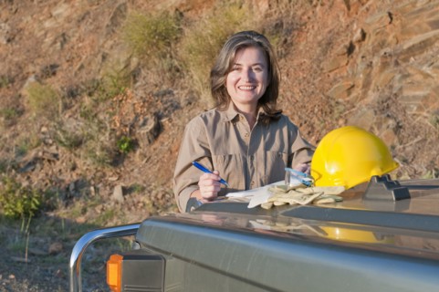 female engineer using car hood as desk
