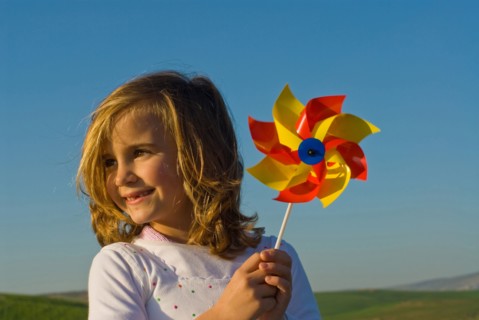 Girl holding pinwheel in field
