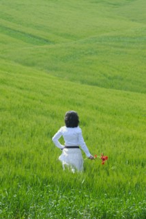 Woman standing in field rear view