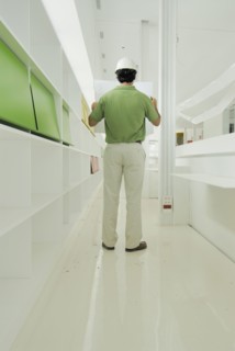 Male architect looking at plan in recently finished office building