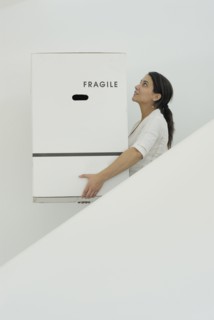 Woman carrying boxes downstairs side view