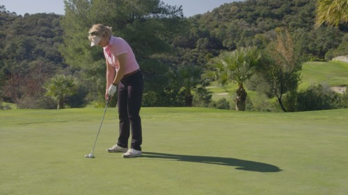 Caucasian woman putting on golf course