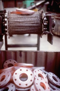 Glowing metal manufactured pieces on conveyor belt