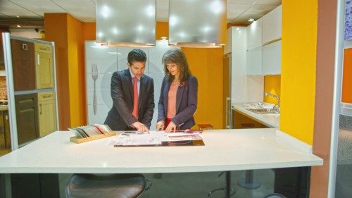 Hispanic salesman showing client samples in kitchen