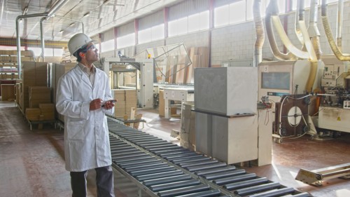 Hispanic worker checking production line in factory