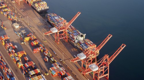 Aerial view of containers and cranes in industrial shipyard