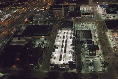 Aerial view of rooftop parking lot lit up at night
