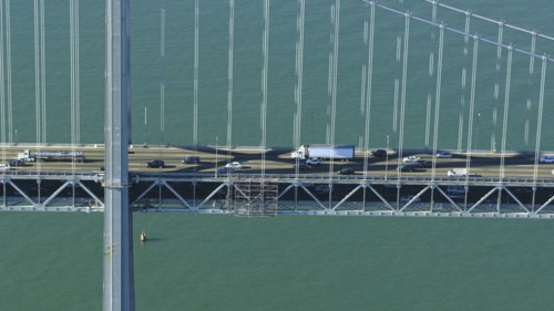 Aerial view of cars and trucks driving on bridge