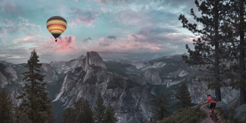 Hot air balloon floating over dramatic mountains