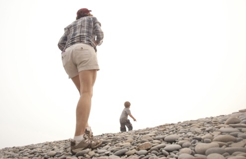 Caucasian mother and son walking on rocky hillside