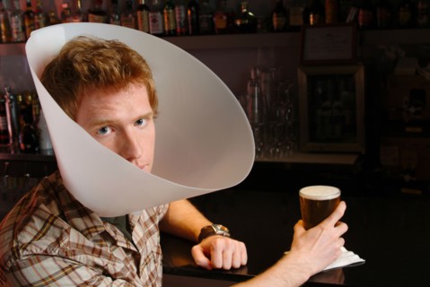 Man wearing medical cone in bar