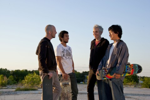 Men holding skateboards in parking lot