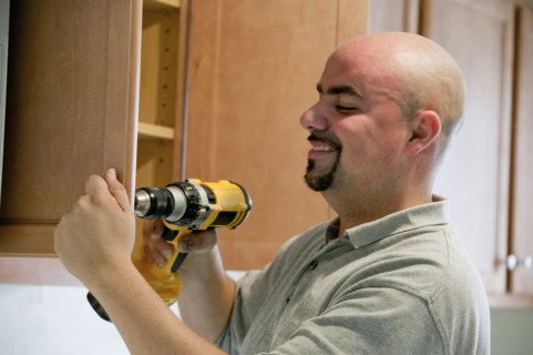 Contractor using power drill in house
