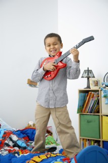 Mixed race boy playing toy guitar