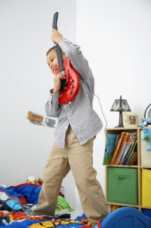 Mixed race boy playing toy guitar