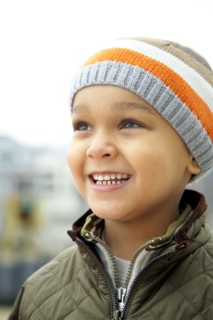 Mixed race boy in cap outdoors