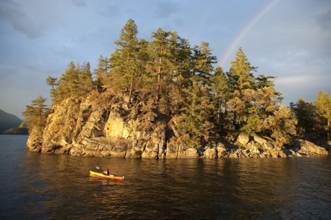 Hispanic woman kayaking on lake
