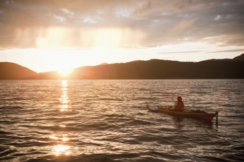 Hispanic woman kayaking on lake