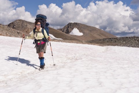 Hispanic woman hiking over snow