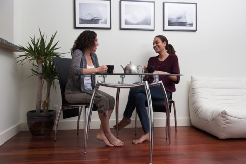 Hispanic women talking and drinking coffee