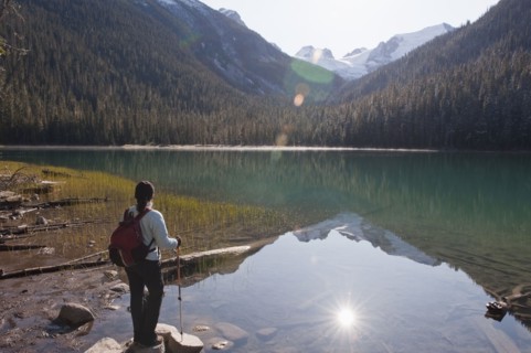 Hispanic hiker standing on rocks near remote lake
