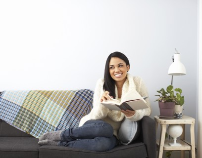 Woman reading book on sofa