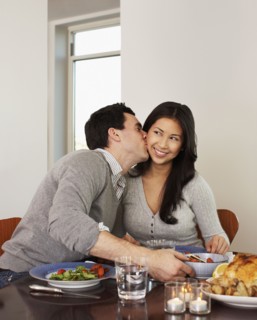 Husband kissing wife at dinner table