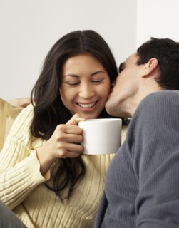 Husband kissing wife drinking coffee