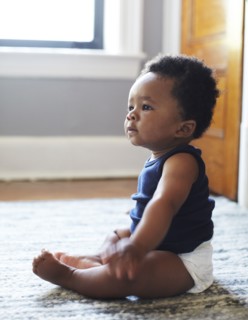 African American baby sitting on floor