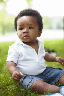 African American baby sitting in grass