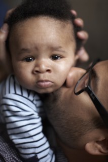 Father kissing African American baby