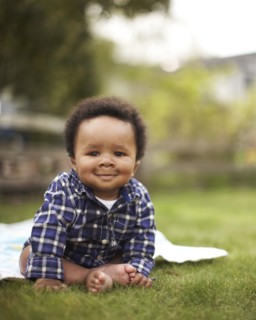 African American baby sitting in grass